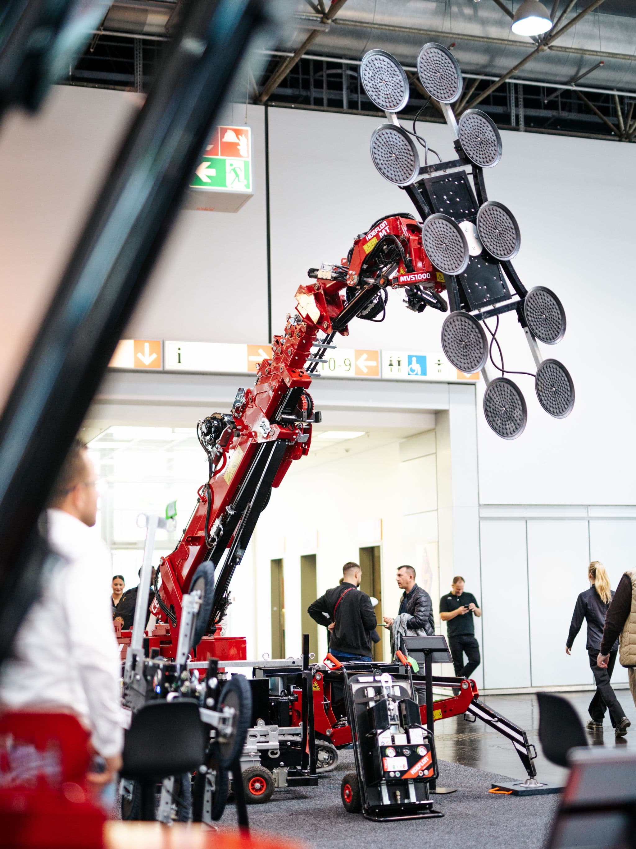 Hoeflon Kran hebt ein Objekt mit einem Glassauger auf einer Messe.