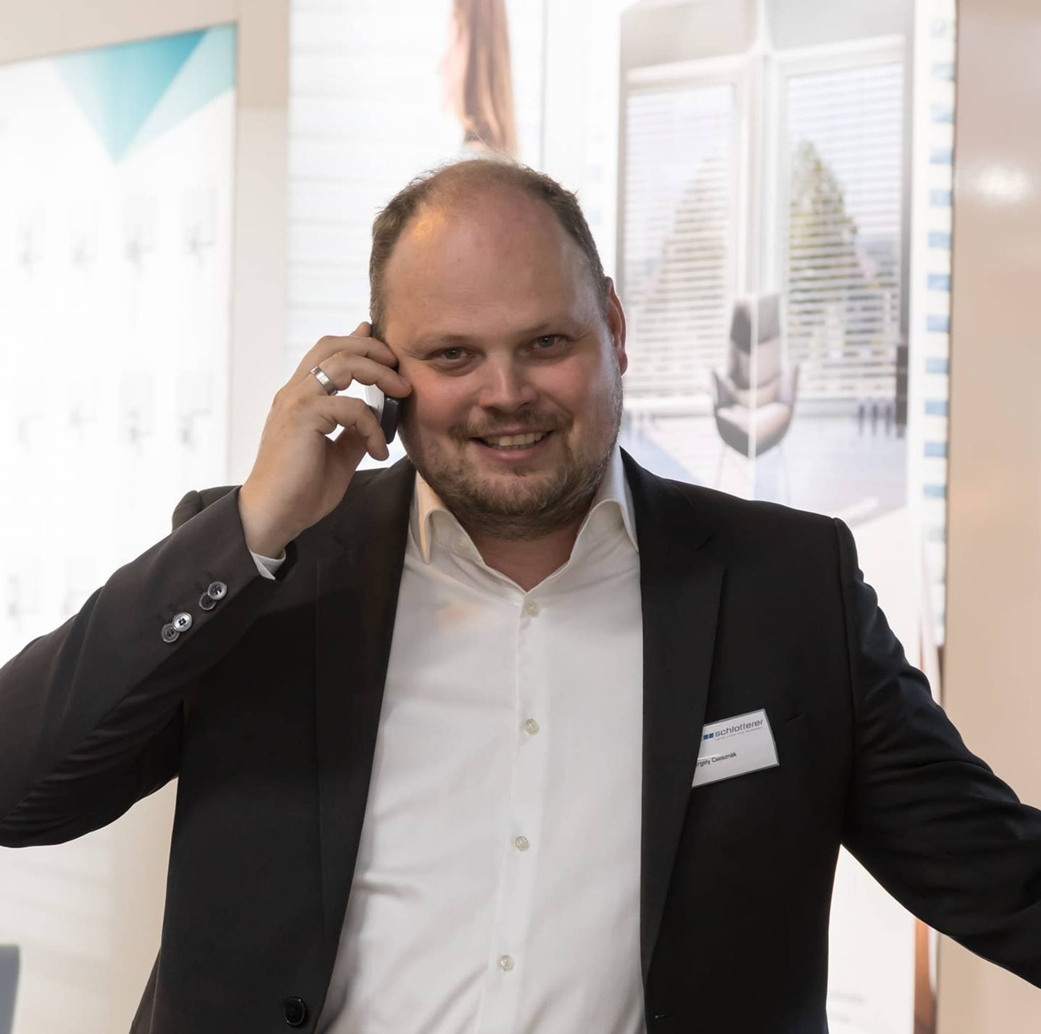 Gergely Metromont, Mann im Anzug, telefoniert auf einer Messe.