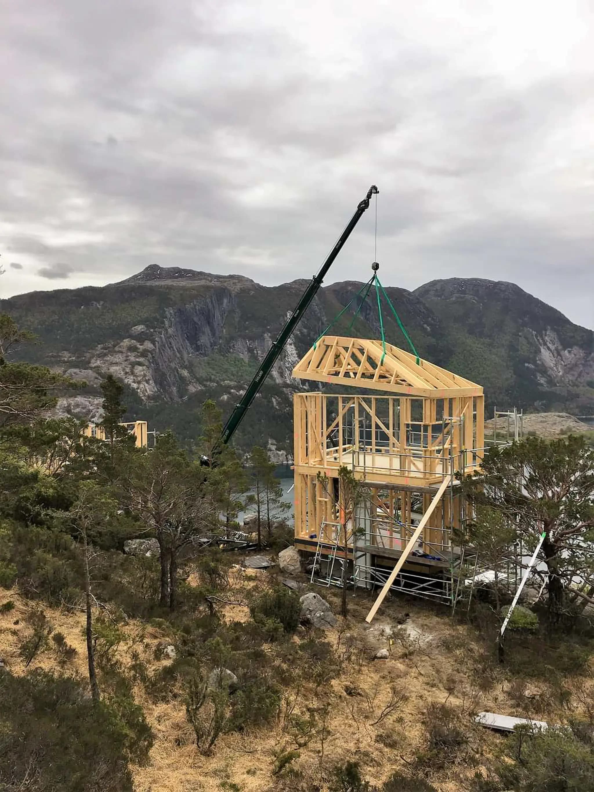 Hoeflon C6e hebt ein Holzrahmen in Norwegen mit Bergen im Hintergrund.